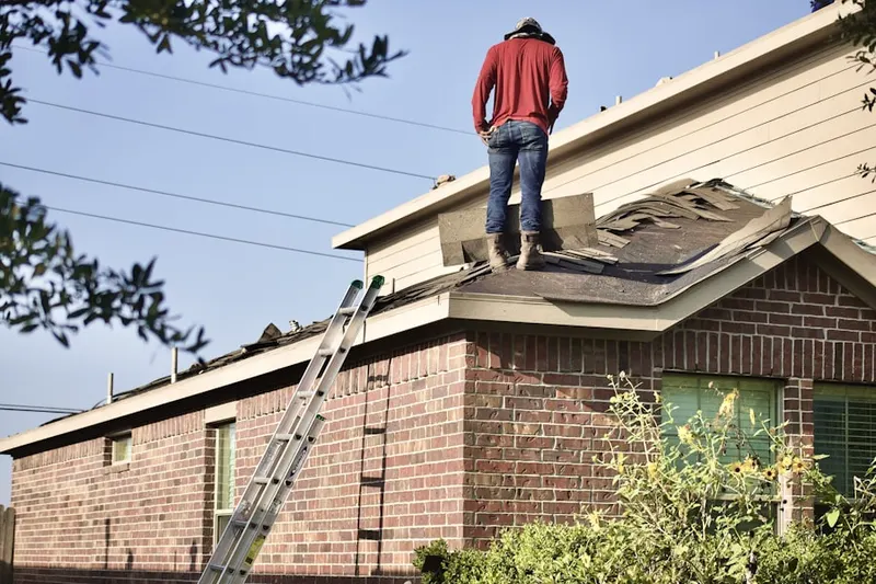 Professional roofer working on a residential roof in Forsonville